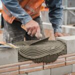 Murarz aplikujący zaprawę